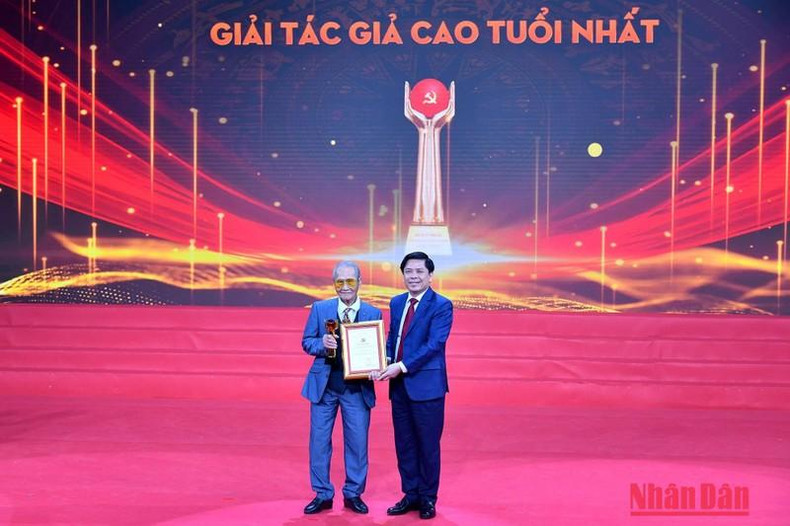 越共中央委员、中央直属机关党委书记阮文体向最年长的作者阮廷安授予奖项。 越共中央委员、中央直属机关党委书记阮文体向最年长的作者阮廷安授予奖项。