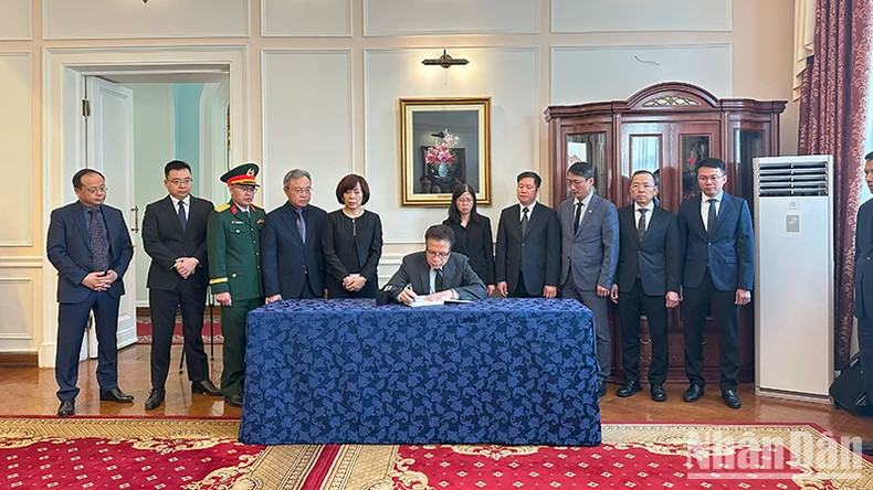 邓明魁大使在吊唁簿上题词。