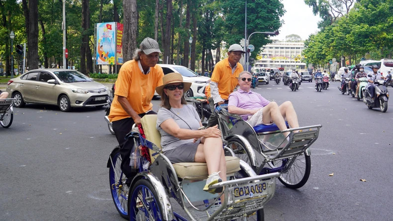游客乘坐三轮车游览胡志明市。 游客乘坐三轮车游览胡志明市。