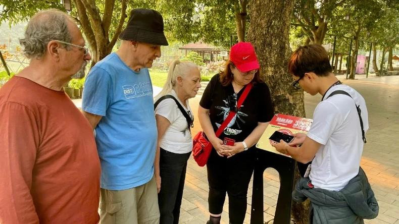 在通岩生态旅游区，国际游客在讲解员的介绍下，对“深爱越南”项目表现出浓厚兴趣，并希望未来该项目能推出外语版本，让更多外国游客能直接体验。