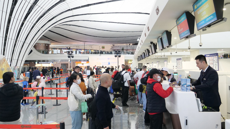 乘客们在北京大兴国际机场的越航柜台办理登机手续。 乘客们在北京大兴国际机场的越航柜台办理登机手续。