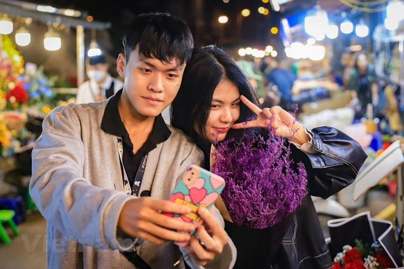 一对年轻人说道:“走在路上就闻到花市的芬芳,忍不住步入花市购买和拍照”。 一对年轻人说道:“走在路上就闻到花市的芬芳,忍不住步入花市购买和拍照”。