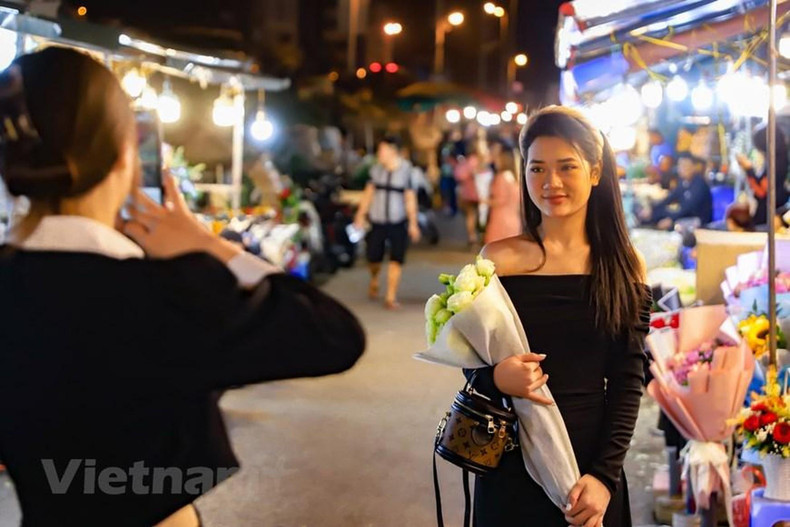 许多年轻人以鲜花为背景拍照做留念。 许多年轻人以鲜花为背景拍照做留念。