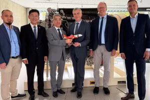 越南驻德国大使阮得成和越捷航空代表向德国联邦航空局领导赠送纪念品。（图片由越南驻德国大使馆提供）