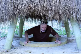 外国游客体验奇英地道当地居民院子里的地道口。（图片来源：越通社）