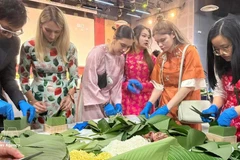 法国年轻人体验包越南粽子。（图片来源：越通社）