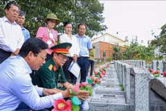 西宁省人民委员会副主席范晋和（左一）与工作团在安静烈士陵园（西宁省安静坊）核查无名烈士墓信息。