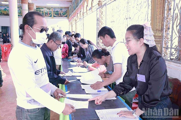 工作人员指导选民完成投票手续。（图片：Duy Toàn）