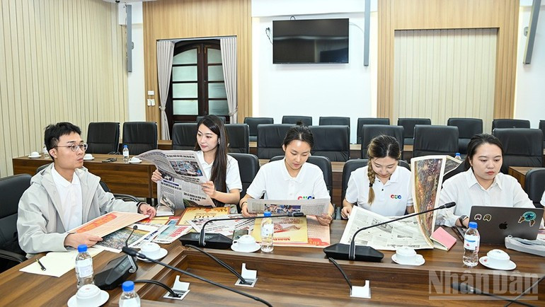 中国传媒大学代表团成员体验《人民报》的创新出版物。（图片来源：世代 摄）