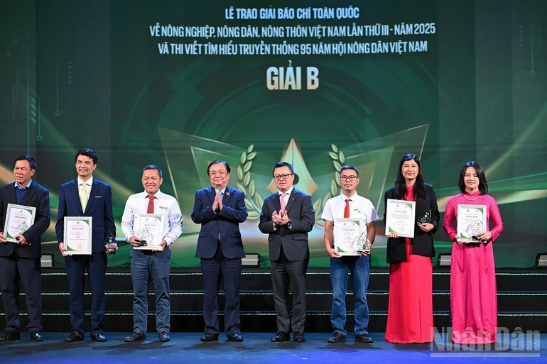 黎明欢、黎国明等同志为获二等奖的作者及代表颁奖。