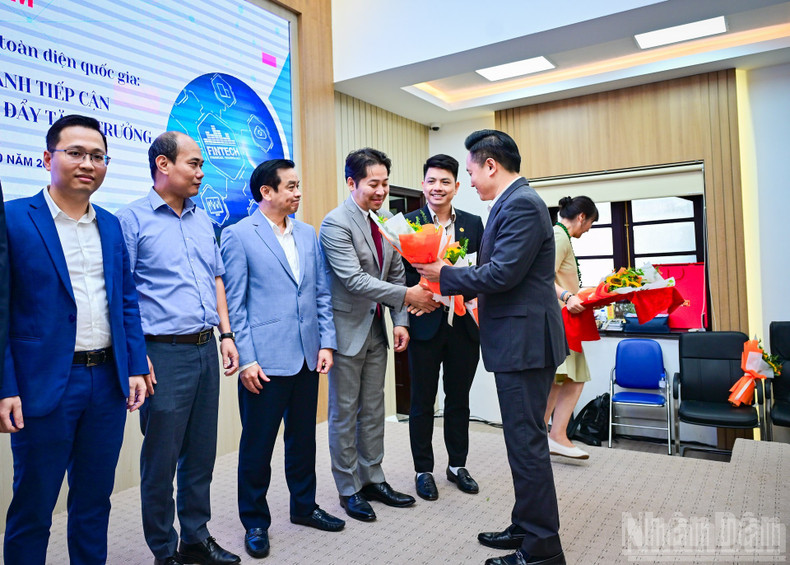 《人民报》社副总编辑潘文雄向座谈会嘉宾赠花致意。 ndo-br-toa-dam-kinh-te-10.jpg