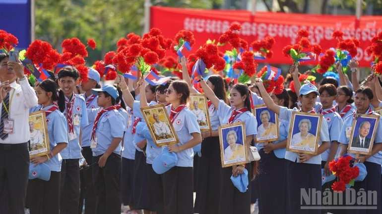 柬埔寨青少年恭敬地向国王车队挥手致意。（图片来源：丁长 摄）