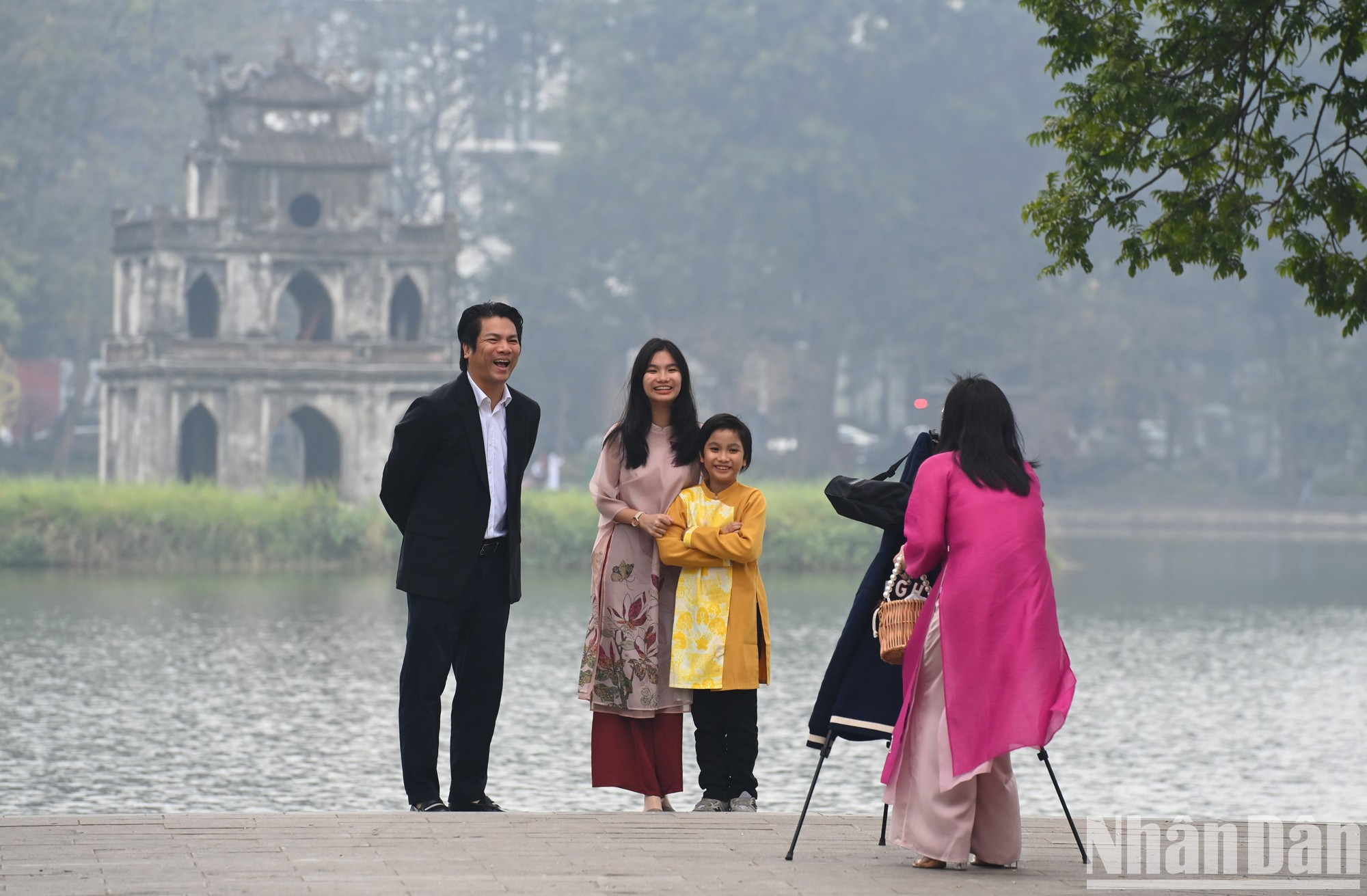 在大年初一雾蒙蒙的早晨，一家人在还剑湖的标志性龟塔前合影留念。