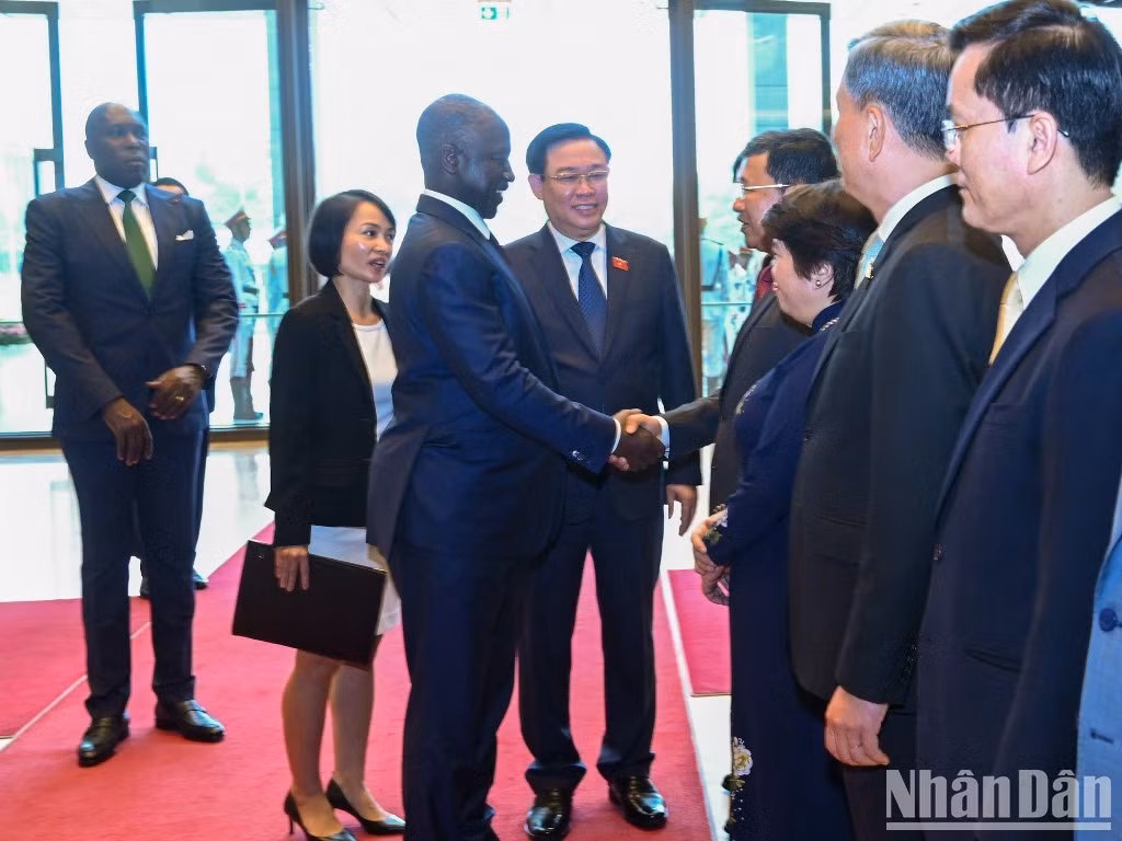 越南国会主席王廷惠向科特迪瓦国民议会议长阿达马·比克多戈介绍越南代表团成员。