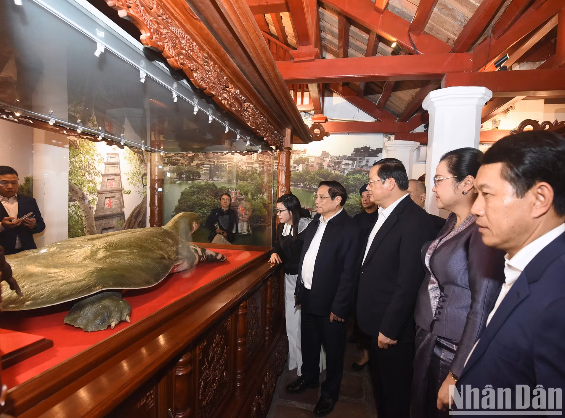 越南政府总理范明正和夫人与老挝政府总理宋赛·西潘敦和夫人听取还剑湖巨龟标本介绍。