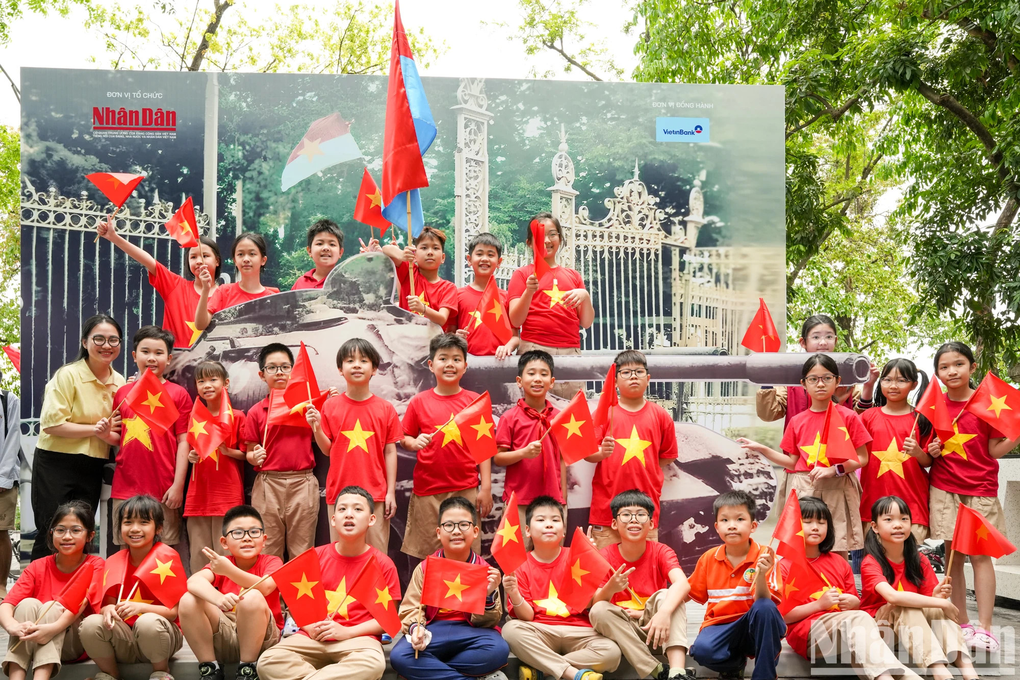 陈国瓒小学的师生们与往年冲破统一宫大门的390号坦克模型拍照。