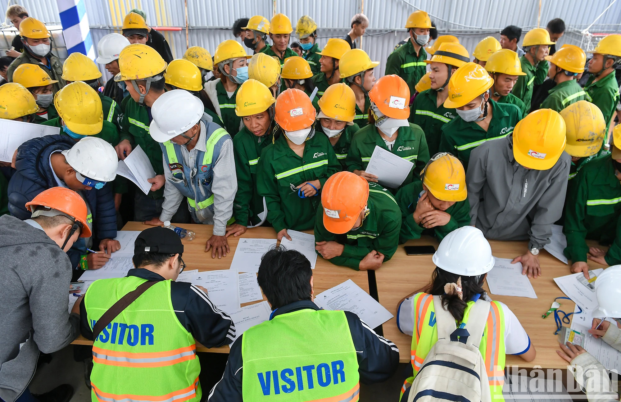 工人们填表，准备在工场上进行体检。