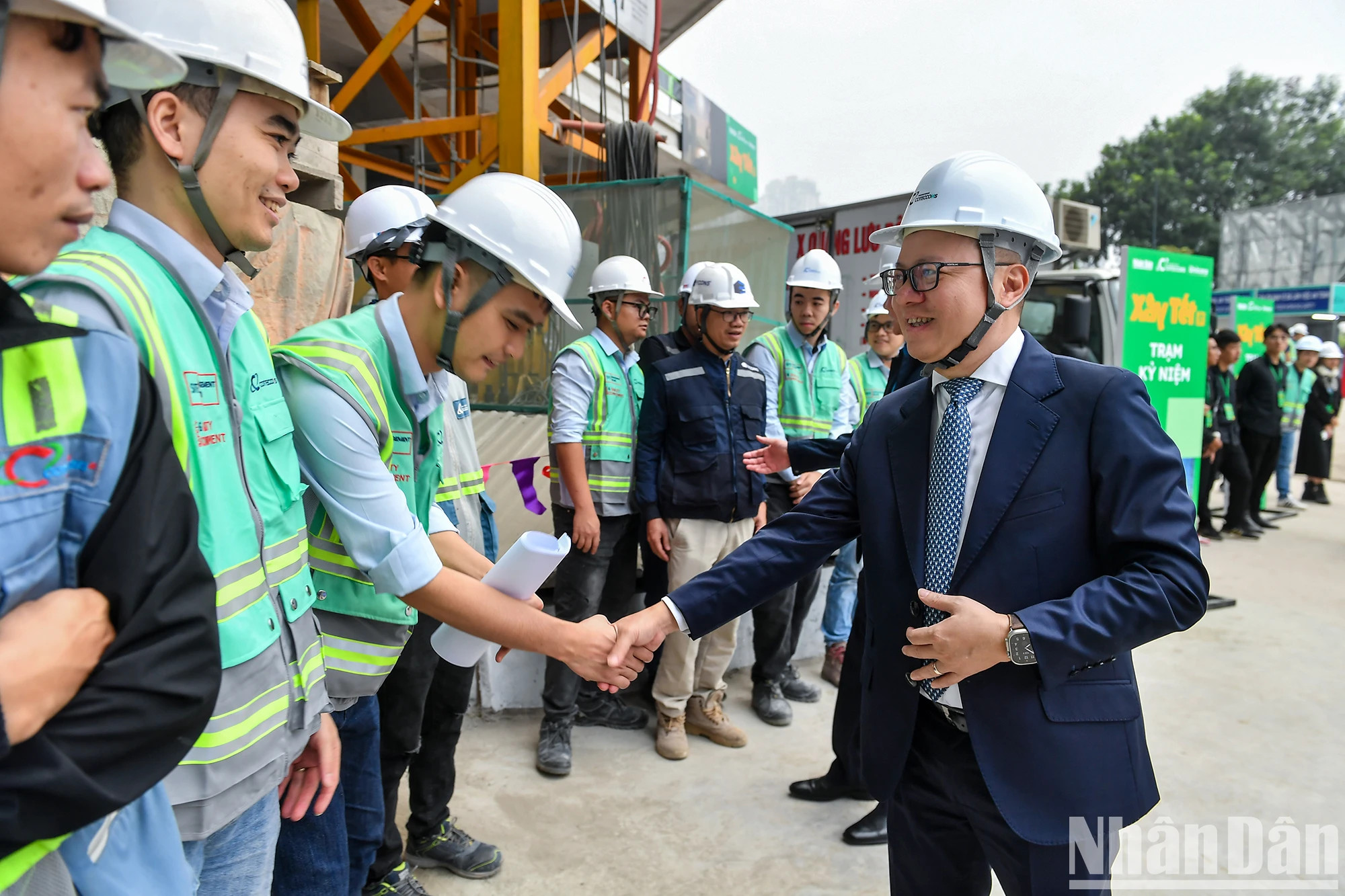 黎国明同志和生态公园工场上的工程师和工人们握着手。