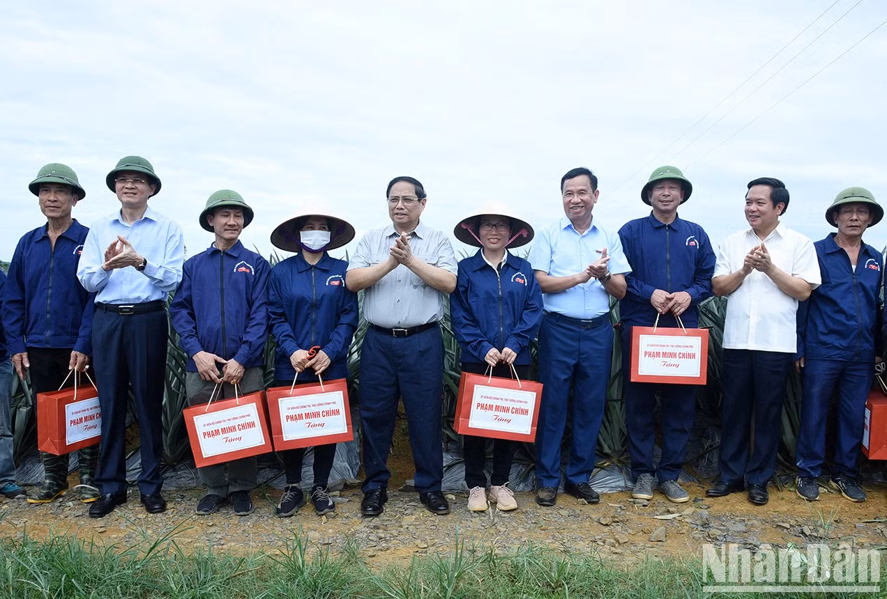 范明正总理向三叠市铜交农场菠萝田里辛勤劳作的工人赠送礼物。