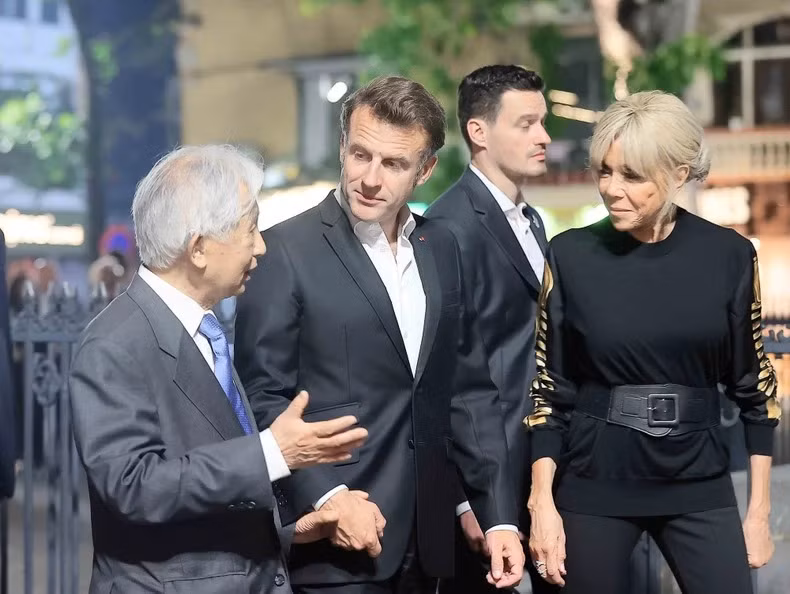 法国总统埃马纽埃尔·马克龙与夫人听取关于河内古街文化特色的介绍。