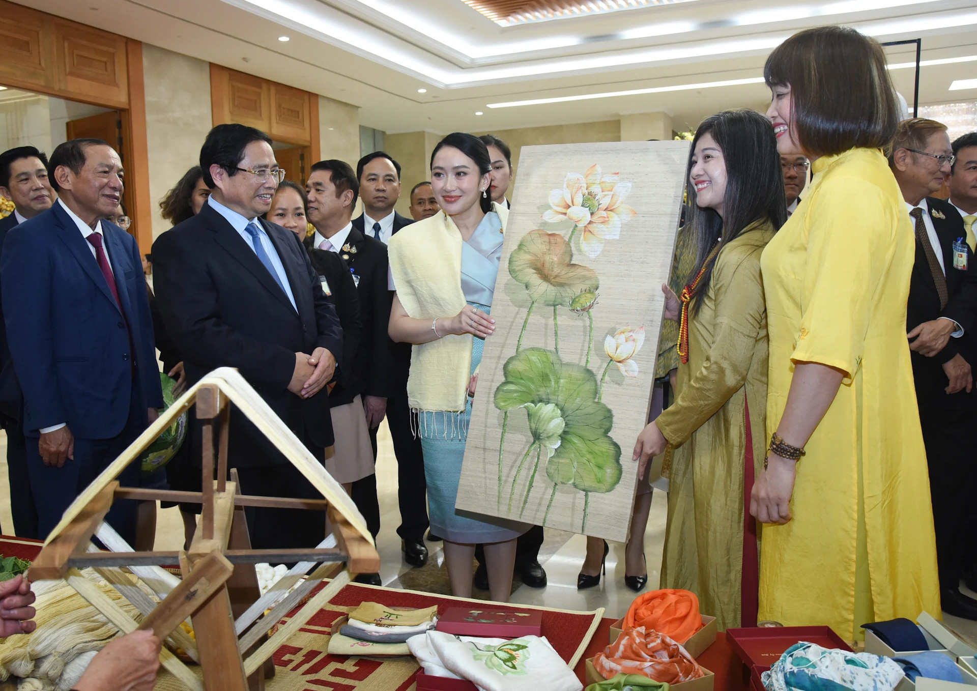 范明正总理与佩通坦总理共同观看民间艺师现场制作的传统手工刺绣产品。