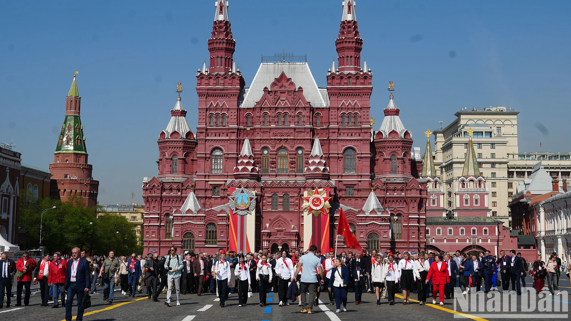 代表们手持旗帜、鲜花和列宁肖像前往列宁陵前。