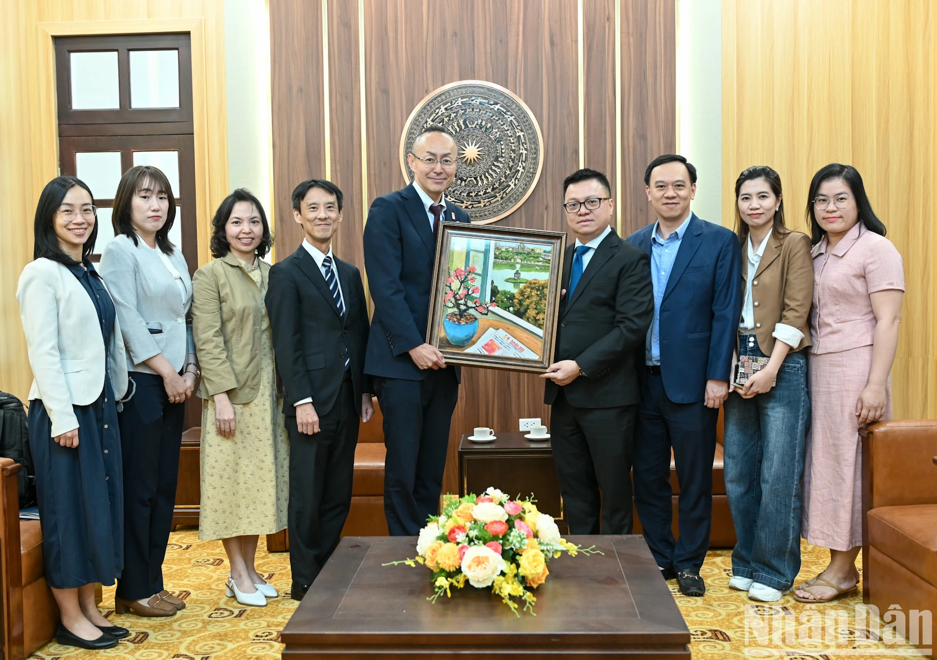 《人民报》社总编辑黎国明向日本国际协力机构代表团赠送纪念画作。
