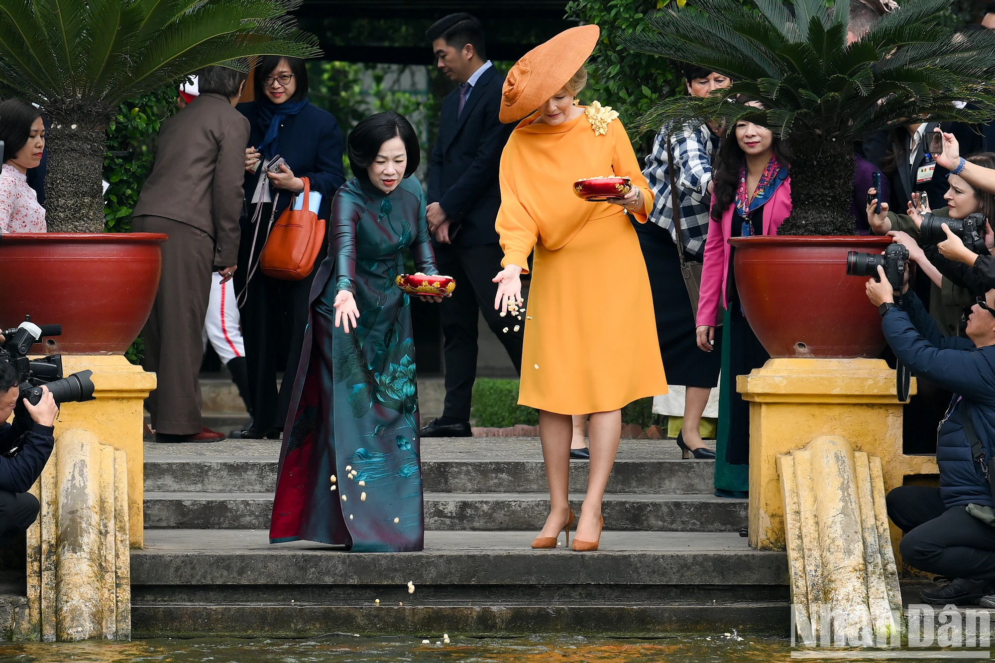 比利时王后玛蒂尔德和越南国家主席夫人阮氏明月参观高脚屋正前方的胡伯伯鱼塘并喂鱼。 比利时王后玛蒂尔德和越南国家主席夫人阮氏明月参观高脚屋正前方的胡伯伯鱼塘并喂鱼。