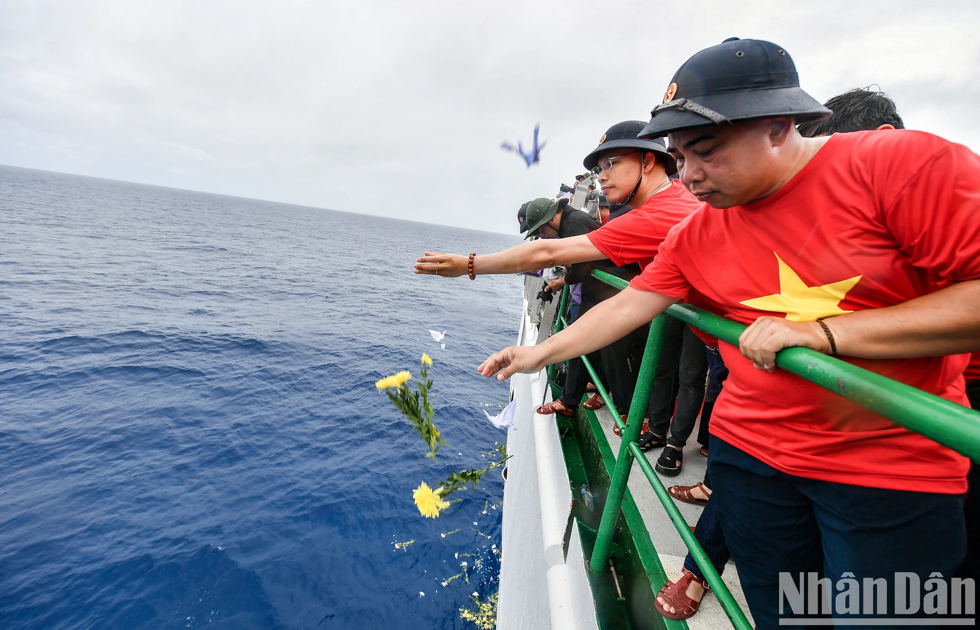 纸鹤和菊花被撒入长沙群岛海域，以缅怀各位永远长眠于大海、献出美好青春的英烈们。