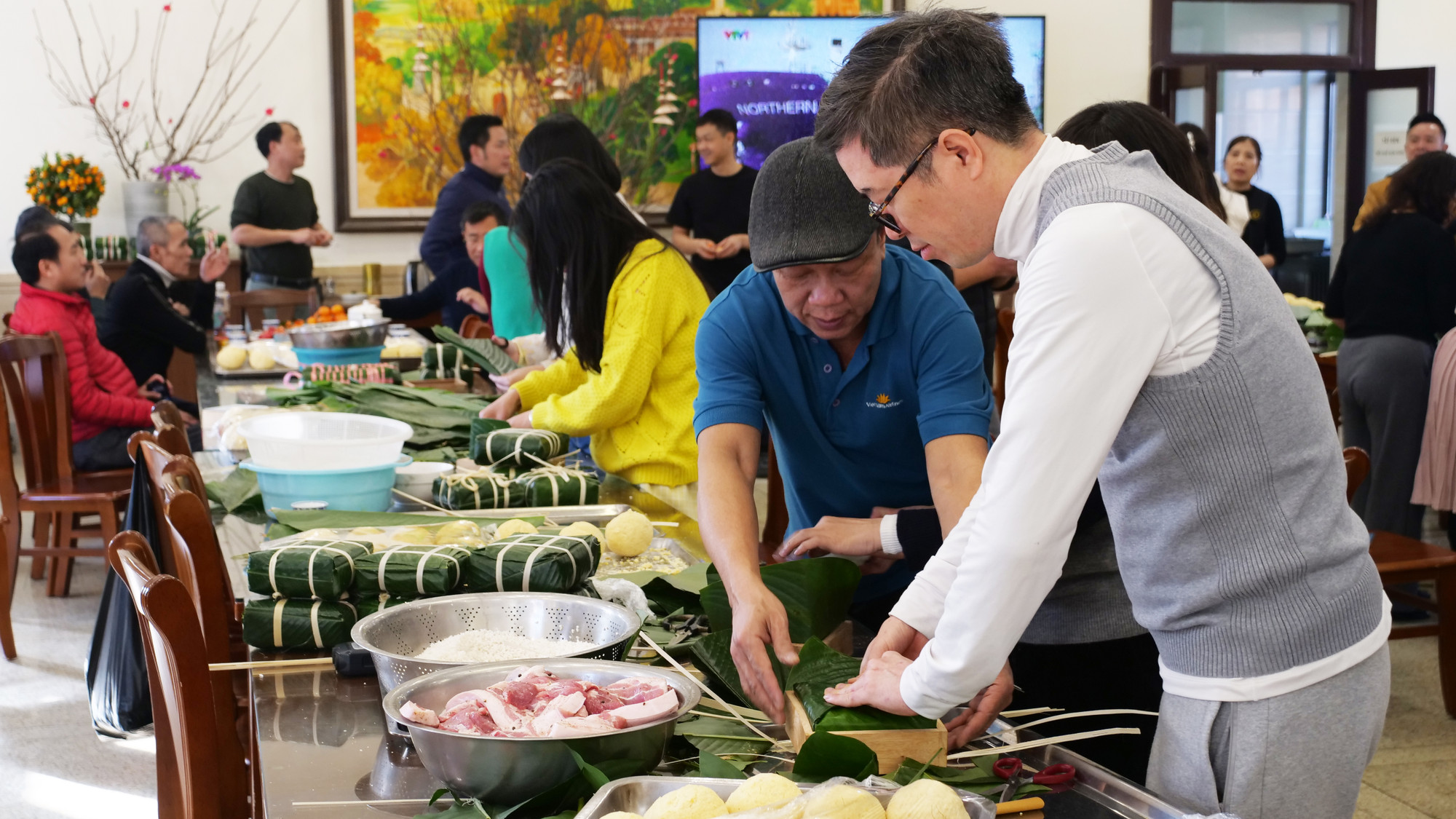 帮助队友包好一个粽子。