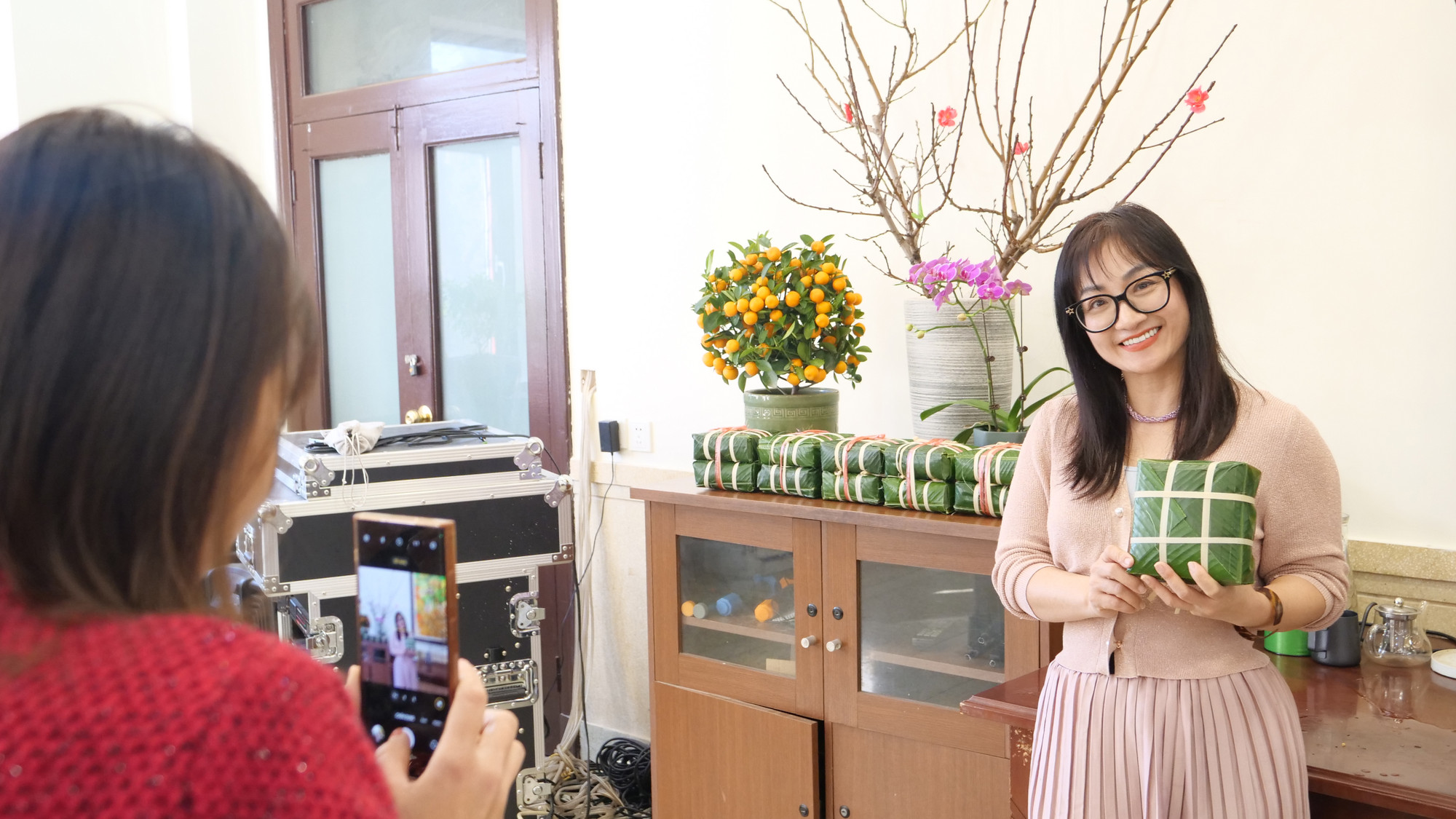 大使夫人手拿着粽子拍照留念。