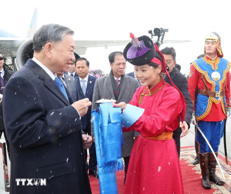 在蒙古国首都乌兰巴托成吉思汗机场，蒙古姑娘按传统习俗献奶糕、送花欢迎苏林总书记、国家主席。（图片来源：越通社）