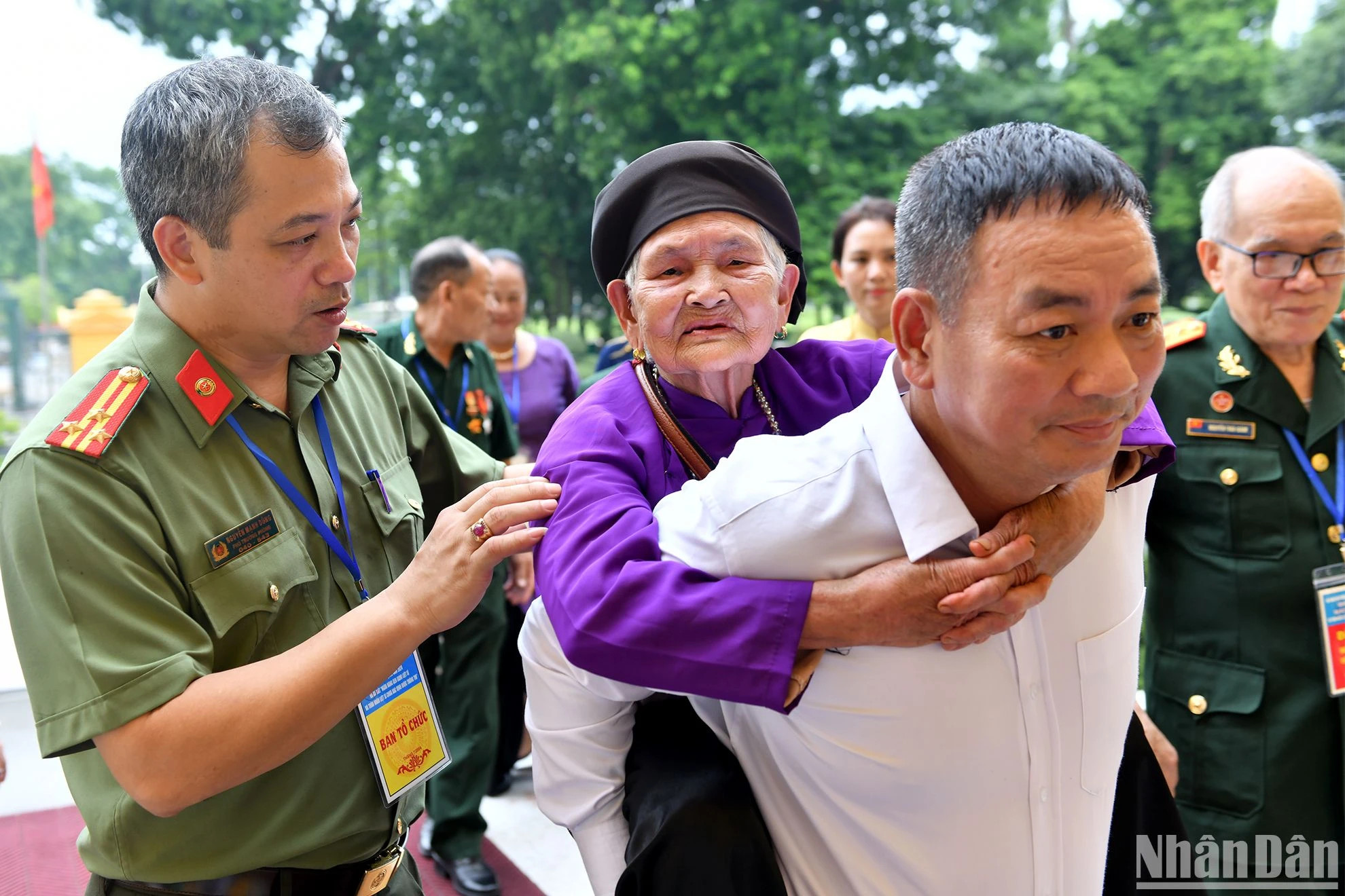 一位越南英雄母亲在亲属的帮助下参加会面。