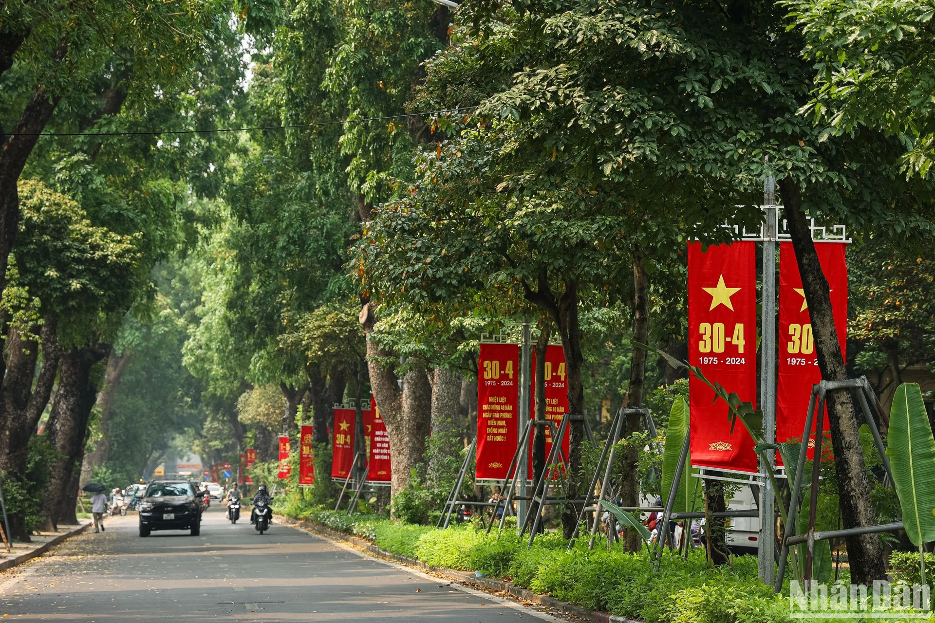 绿树成荫的黄耀街挂着红色的横幅和标语,庆祝南方解放和国家统一49周年。 绿树成荫的黄耀街挂着红色的横幅和标语,庆祝南方解放和国家统一49周年。
