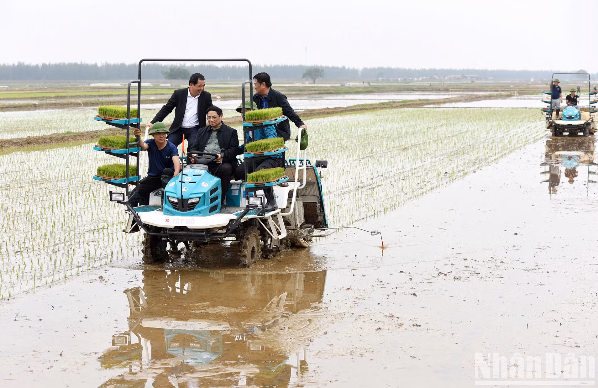 范明正总理在兴龙乡稻田上亲自驾驶插秧机体验操作。