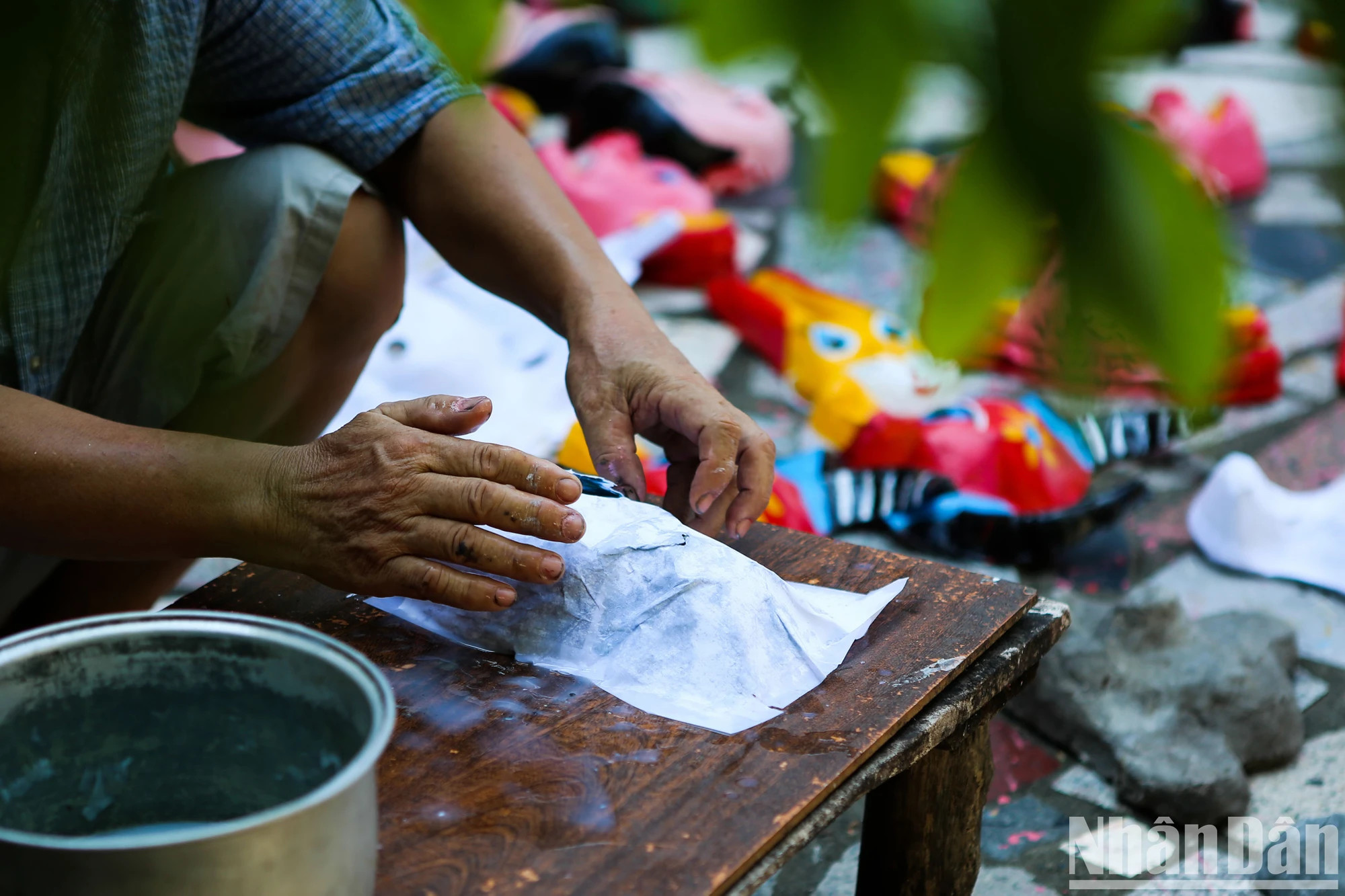 每个面具都是用不同的水泥模具制成的，工匠将每一层纸铺好并涂上胶水。