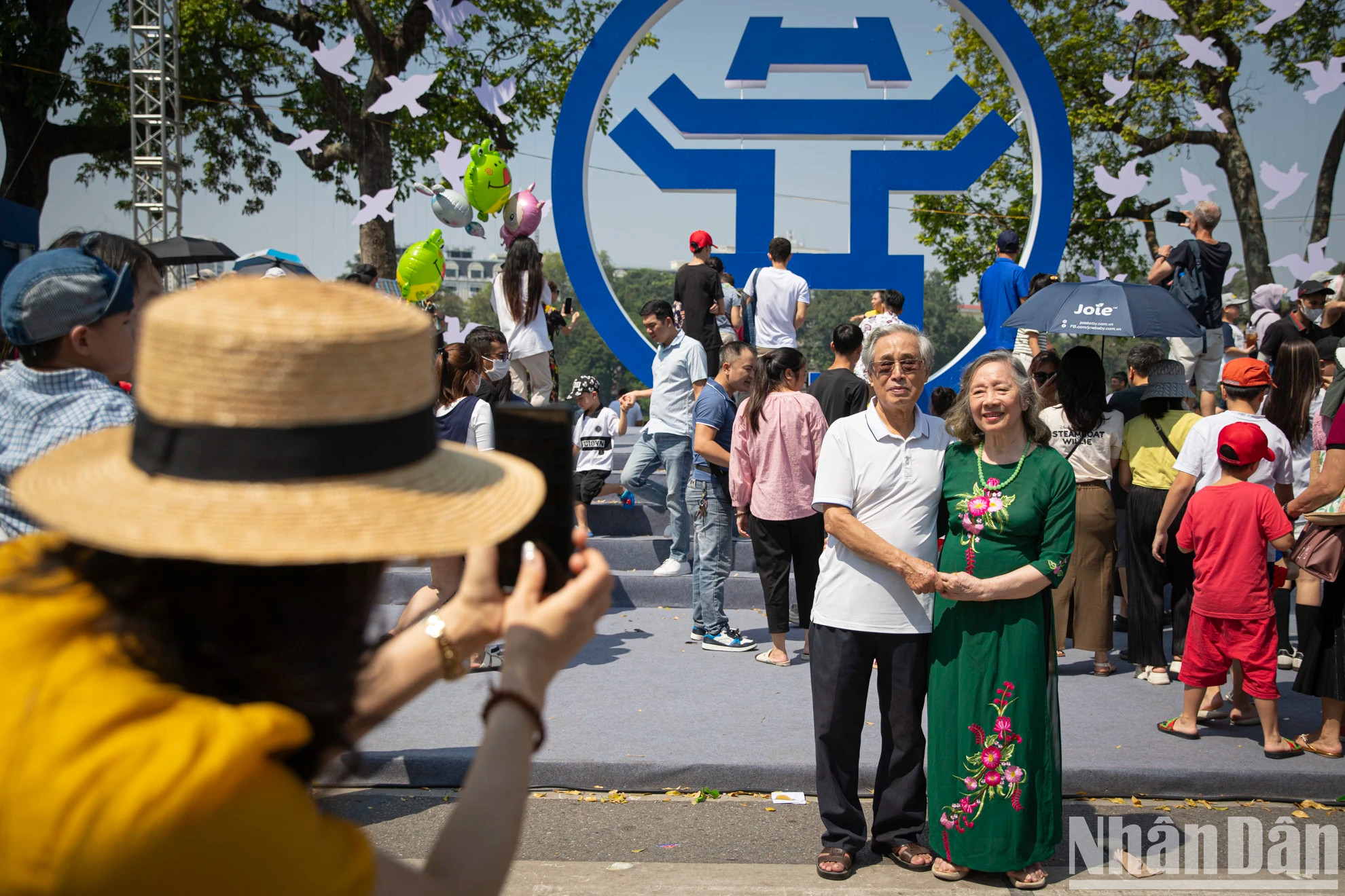 人民在李太祖雕像前与河内的象征合影留念。