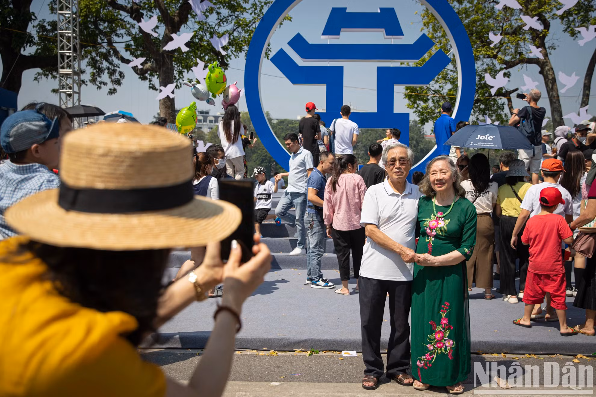 人民在李太祖雕像前与河内的象征合影留念。