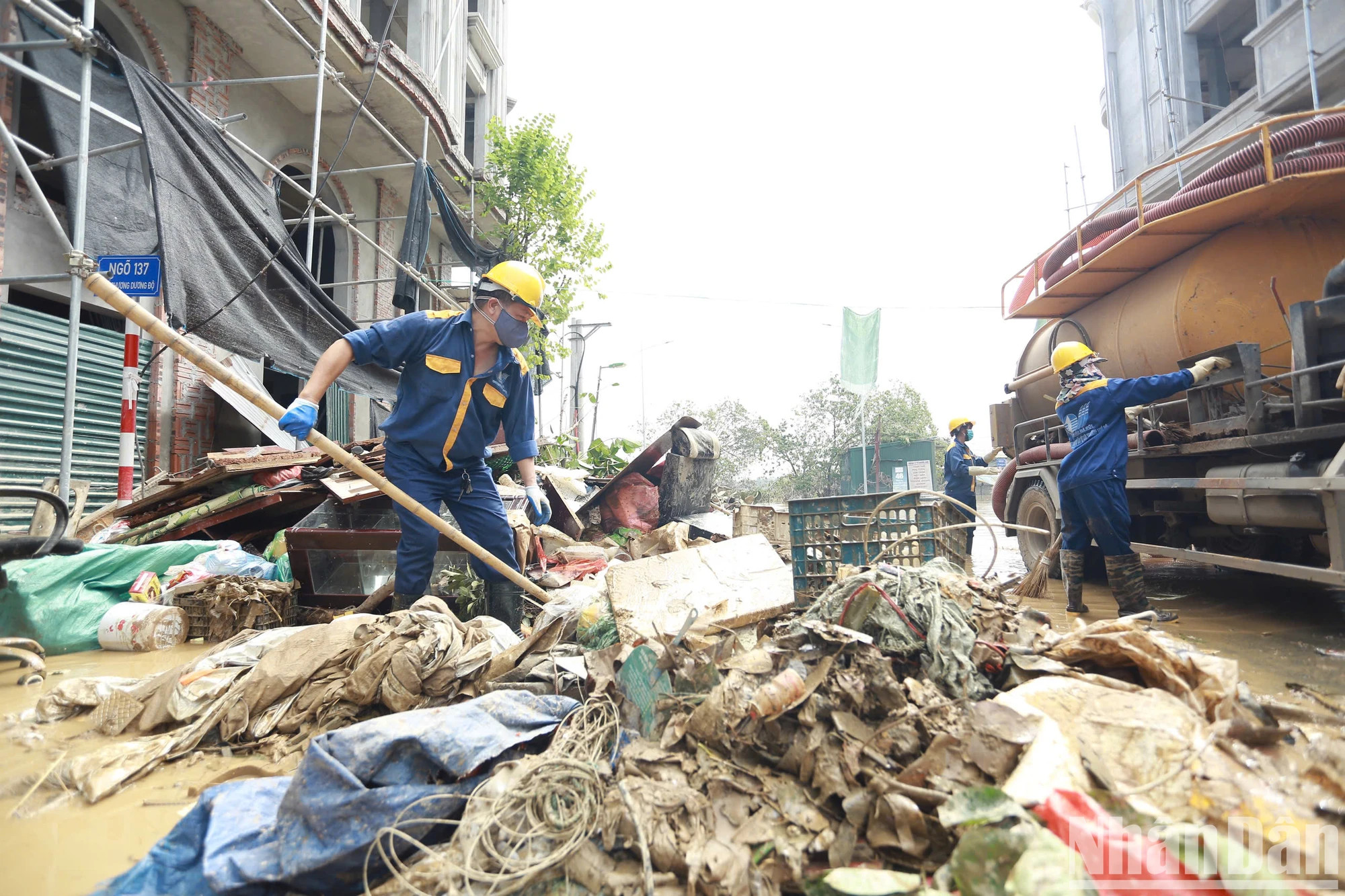 河内市排水一成员责任有限公司的人员正在协助居民清理洪水后的垃圾。 河内市排水一成员责任有限公司的人员正在协助居民清理洪水后的垃圾。