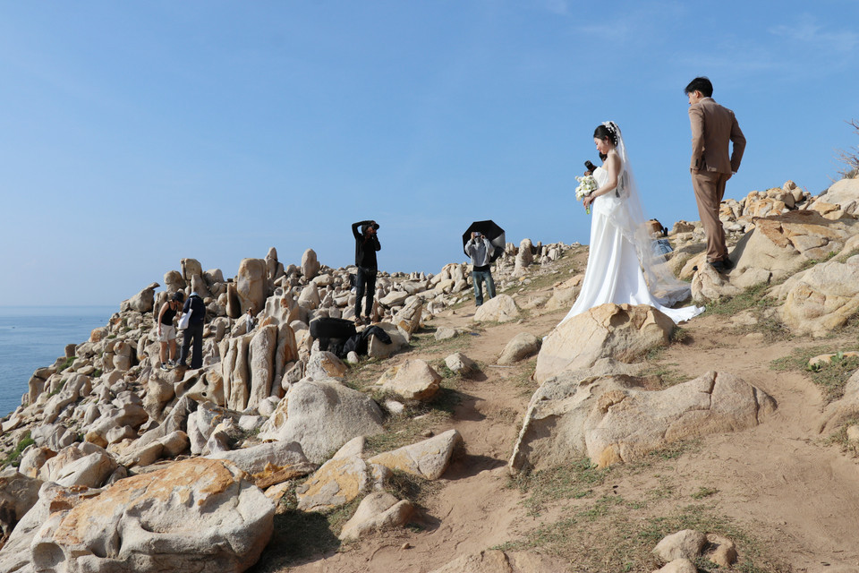 游客在宁顺省宁海县永海乡的主山国家公园岩石公园内拍照留影，记录下这片奇岩美景带来的震撼与感动。