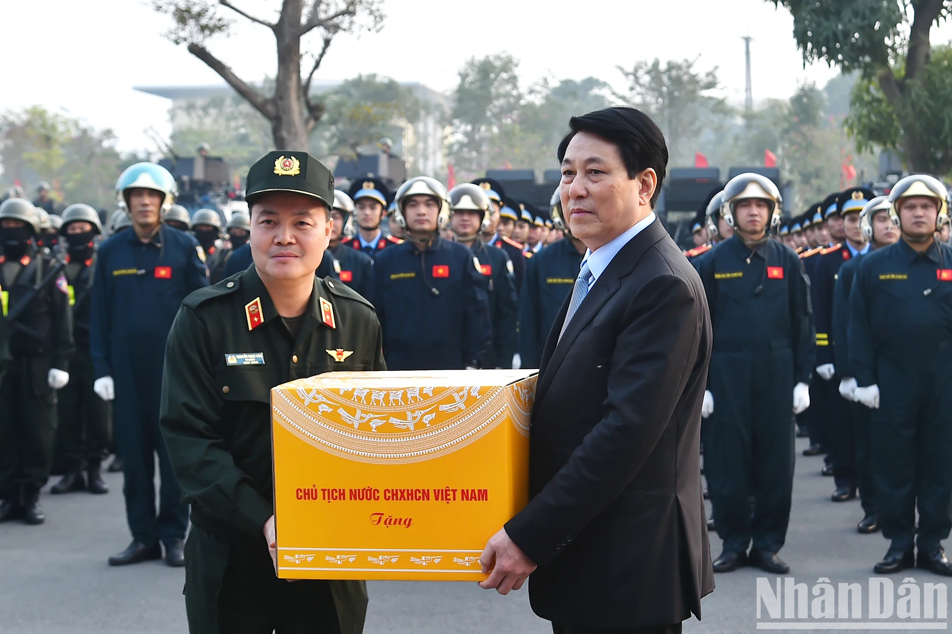 国家主席梁强向机动警察司令部官兵赠送礼物。