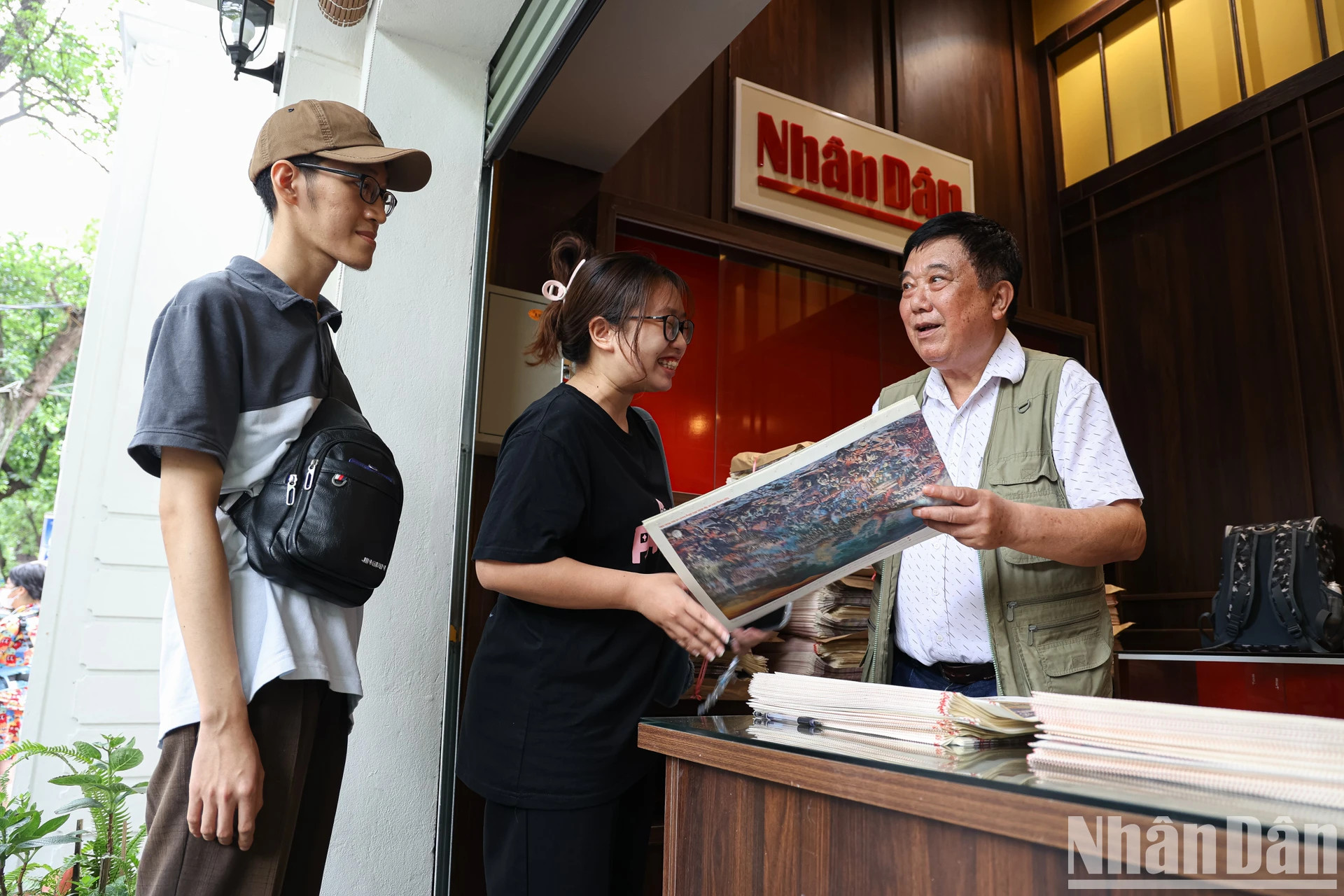 《奠边府战役》 全景图作者小组组长阮文莫画家向读者赠送全景图副刊。 《奠边府战役》 全景图作者小组组长阮文莫画家向读者赠送全景图副刊。