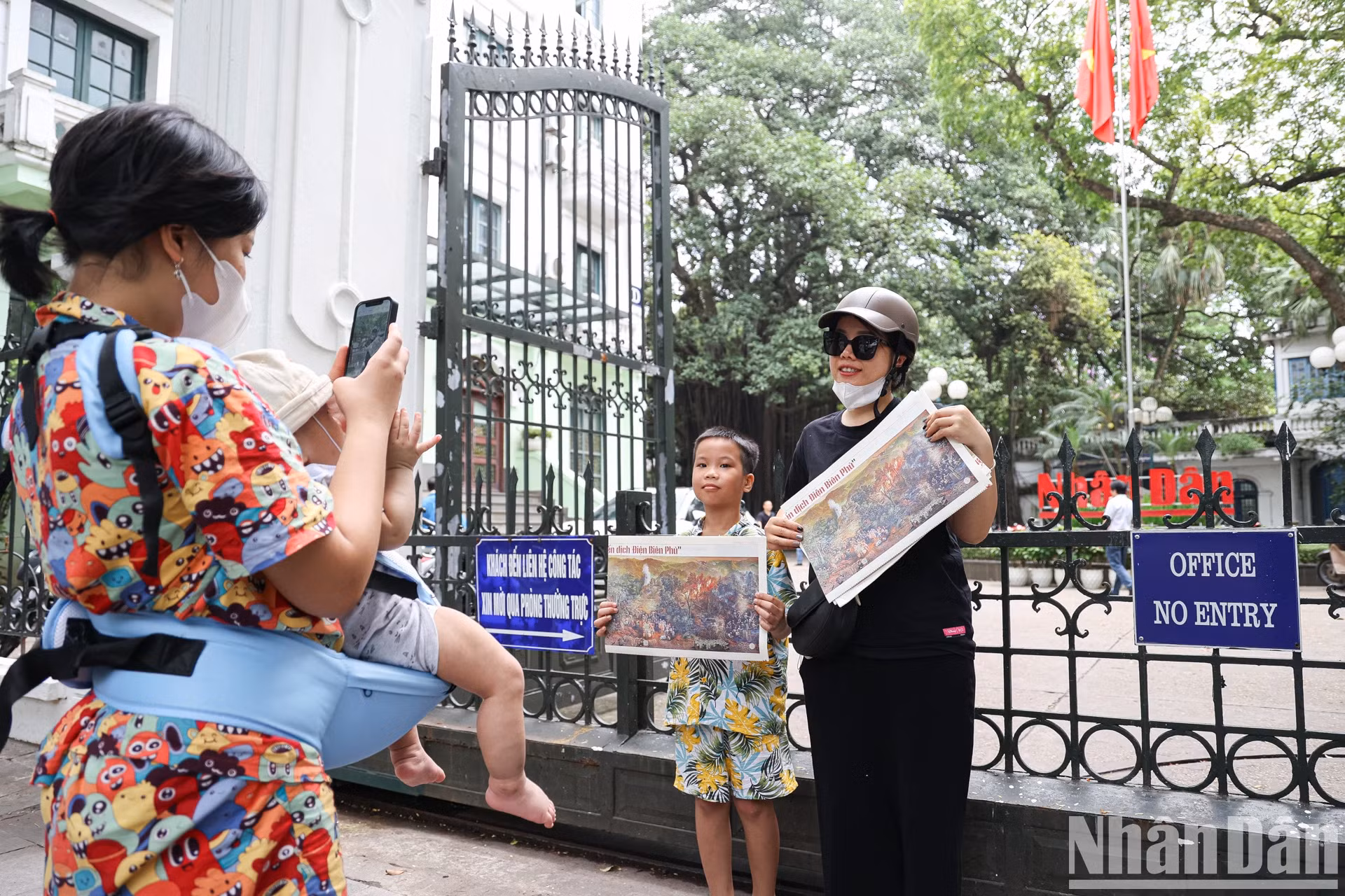 人们携带全景图在《人民报》社总部门口拍纪念照。