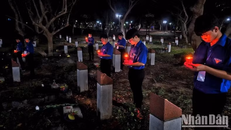 胡志明共青团团员在英雄烈士墓前点燃蜡烛表达感恩。