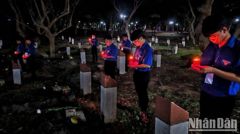 胡志明共青团团员在英雄烈士墓前点燃蜡烛表达感恩。