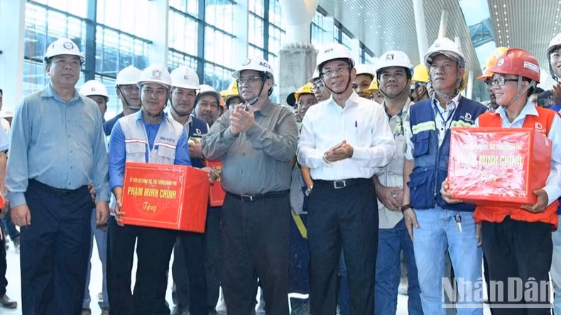 范明正总理向工程师、工人赠送礼物。 范明正总理向工程师、工人赠送礼物。