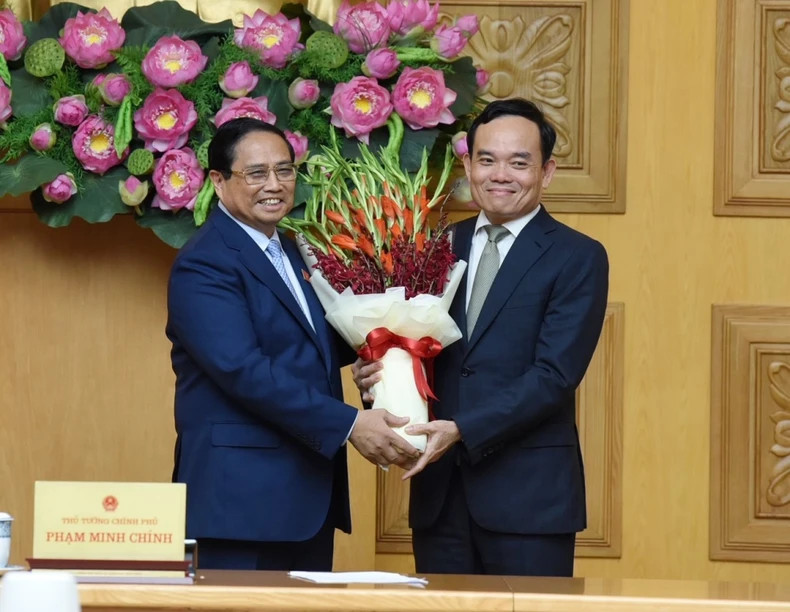 范明正总理送鲜花祝贺中央经济部部长陈流光。