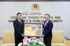 河内市公安局局长阮青松中将（右）会见老挝人民革命党中央书记、公安部长万通·孔玛尼上将。