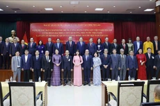 苏林总书记，越南驻老挝大使馆工作人员，旅居老挝越南人代表，和各位代表合影。（图片来源：越通社）