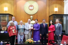 越南祖国阵线中央委员会副主席何氏娥向英国共产党总书记罗伯特·格里菲思赠送纪念品。